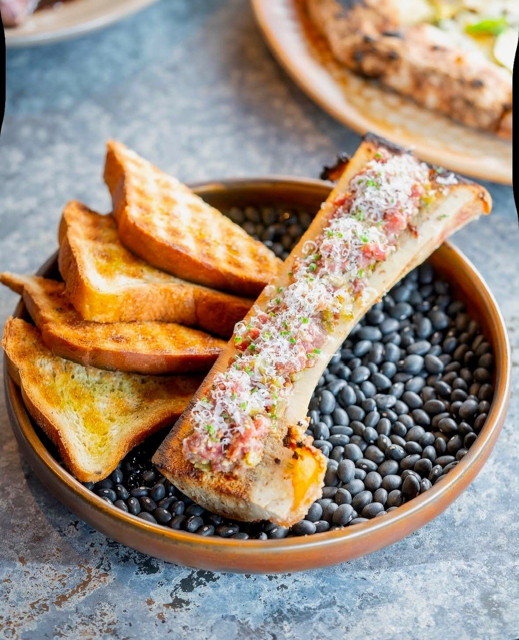 Experience Ember, a standout in Ottawa's Byward Market. Enjoy Argentinian charcoal-grilled dishes, wood-fired pizza, creative cocktails, and live music in a stunning setting.