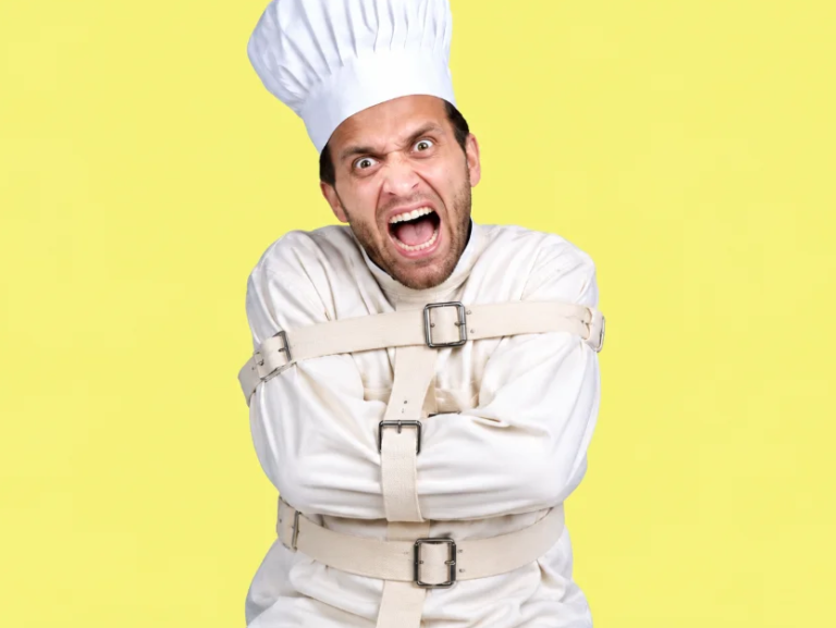 A man wearing a white chef's hat and a white straitjacket screams with wide eyes and an open mouth, looking directly at the viewer. His face is contorted in an expression of extreme frustration or madness, and his arms are bound across his chest by the straitjacket's straps. The background is a solid bright yellow.